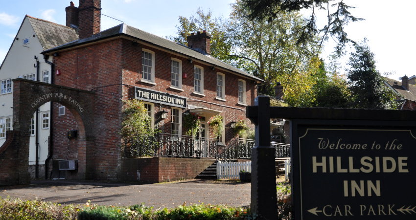 house with a sign in front reading Hillside Inn