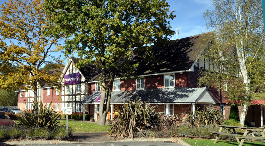 hotel building with trees and parked cars